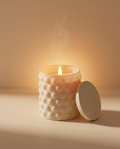 Emberless flameless candle diffuser in cream bubble glass, lit at dusk with lid beside it